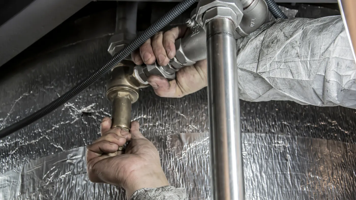Fontanero trabajando en una reparación de tuberías